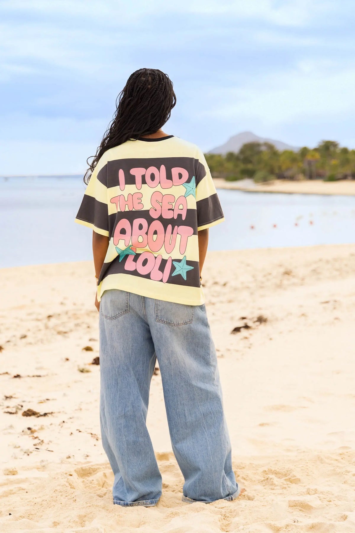 Femme de dos portant le t-shirt rayé jaune et noir Loli Seaside avec imprimé rose